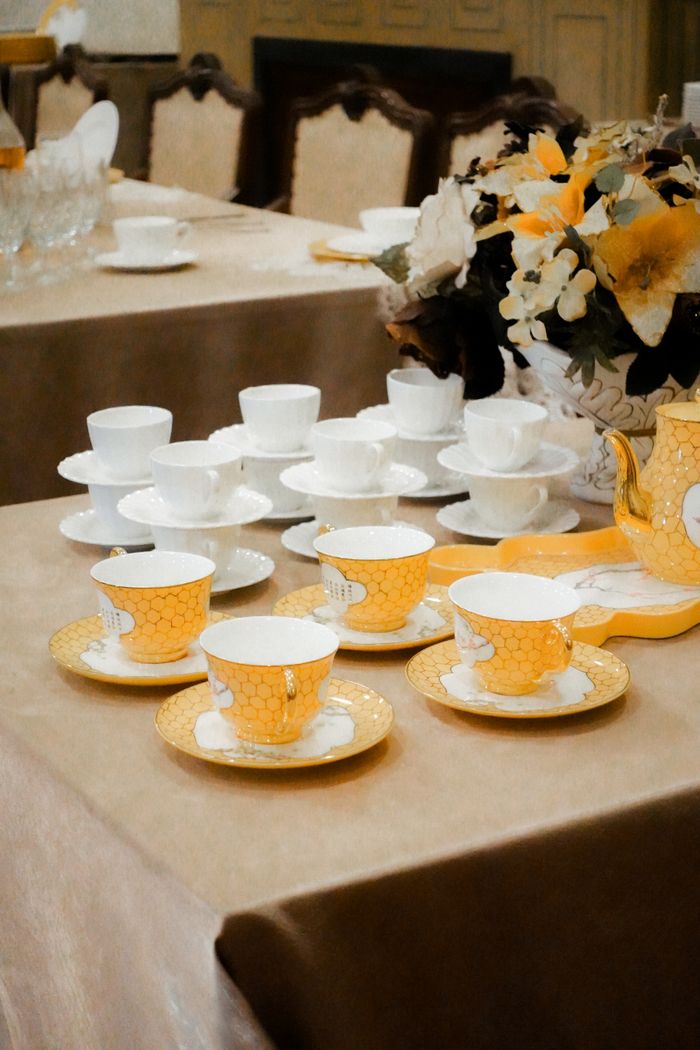A beautifully arranged tea set with porcelain cups and saucers on a dining table.